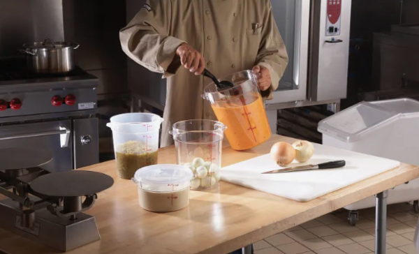 Chef stirring contents in a round clear food storage container